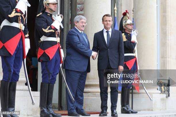 French president Emmanuel Macron welcomes Algerian Prime Minister Ahmed Ouyahia at the Elysee Palace in Paris on May 29, 2018 prior an international...