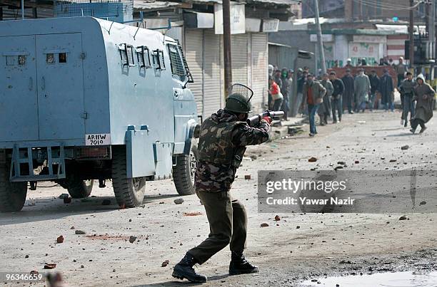 An Indian police officer aims his teargas rifle towards Kashmiri protesters during a protest against the death of a 14 year-old Wamiq Farooq on...