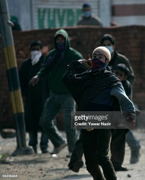 Kashmiri protester throws stones at Indian police officers during a protest against the death of a 14 year-old Wamiq Farooq on February 02, 2010 in...