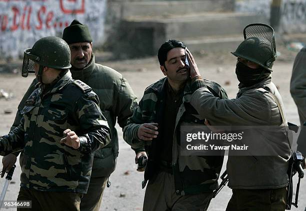 Indian police officers help an Injured colleague after he was hit by a stone trhown by Kashmiri protesters at him during a protest against the death...