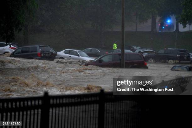 Cars are stranded in a parking lot during a flash flood May 27, 2018 in Ellicott City, MD. This comes two years after another flash flood devastated...