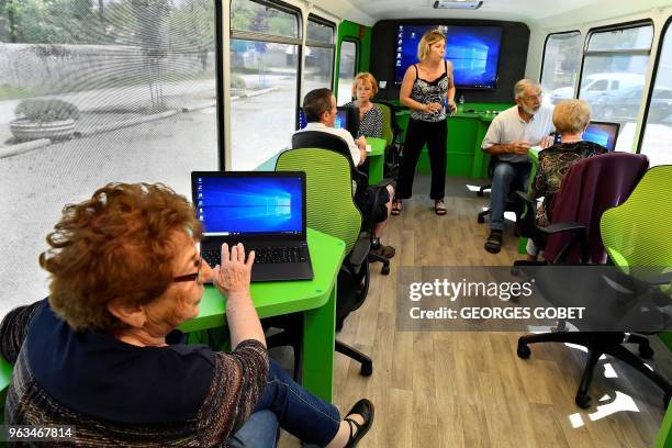 Elderly people attend a computer workshop in the "digital bus in Villandraut, near Sauternes, southwestern France, on May 22, 2018. - The "digital...