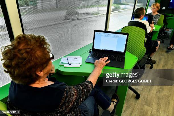 Elderly people attend a computer workshop in the "digital bus in Villandraut, near Sauternes, southwestern France, on May 22, 2018. - The "digital...