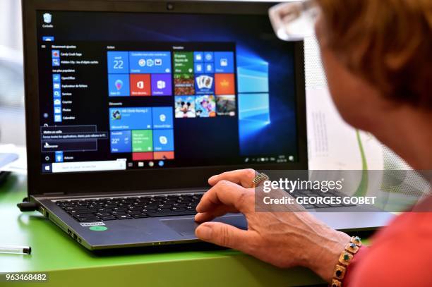 An elderly woman reads on a screen during a computer workshop in the "digital bus in Villandraut, near Sauternes, southwestern France, on May 22,...