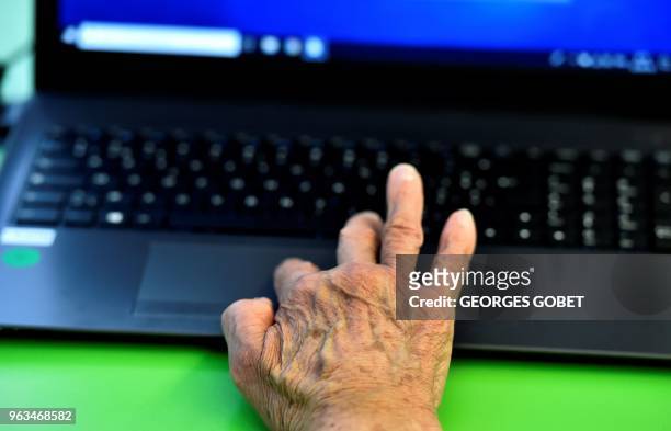 An elderly person uses a computer during a computer workshop in the "digital bus in Villandraut, near Sauternes, southwestern France, on May 22,...