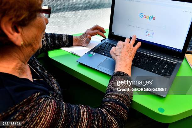 An elderly person uses a computer during a computer workshop in the "digital bus in Villandraut, near Sauternes, southwestern France, on May 22,...