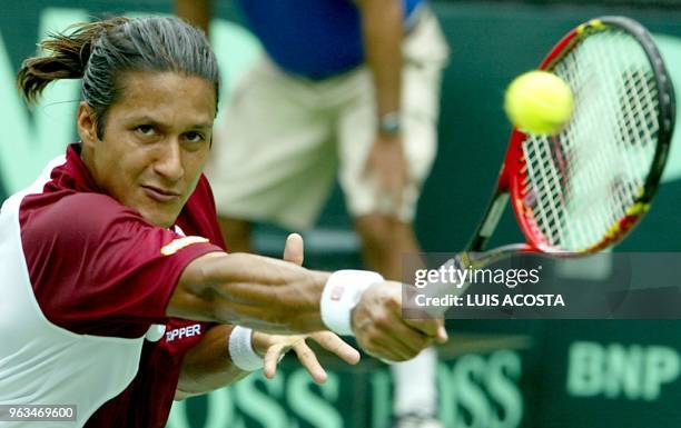 El tenista venezolano Kepler Orellana retorna la bola al brasileño Bruno Rosa durante su juego por la Copa Davis en Caracas el 17 de julio de 2004...