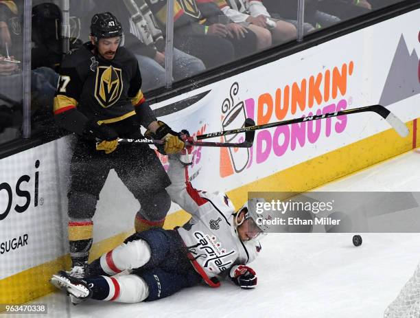 Luca Sbisa of the Vegas Golden Knights and Andre Burakovsky of the Washington Capitals crash into the boards in the second period of Game One of the...