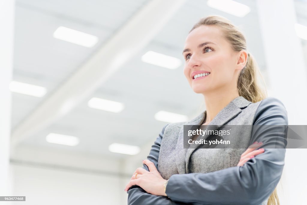 Businesswoman at warehouse with arms crossed