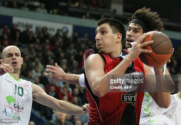Lietuvos Rytas' Martynas Gecevicius vies with Unicaja's Carlos Jimenez and Georgios Printezis during their Euroleague basketball Championship match...