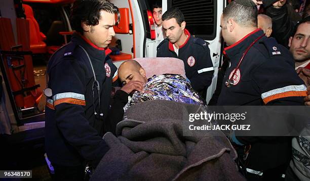 Israeli magician Hezi Dean is evacuated after he left from inside an eight-tonne block of ice at Rabin Square in Tel Aviv on December 31, 2009. An...