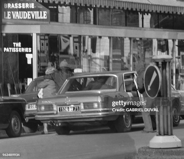 Gangsters flee with one of their three hostages aboard a Mercedes 450 after a robbery at Crédit de la Bourse bank on January 31, 1974 on Place de la...