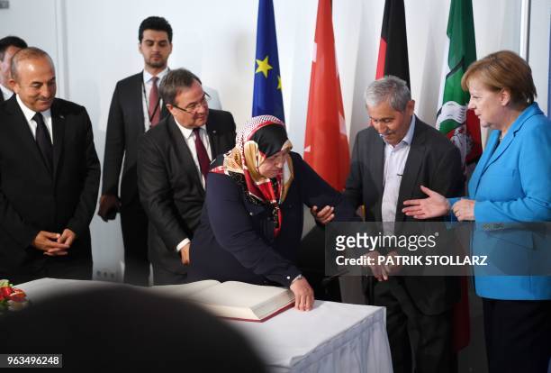 Mevlude Genc , mother, grandmother and aunt of the victims stands up after signing the guestbook as her husband Durmus Genc helps beside German...