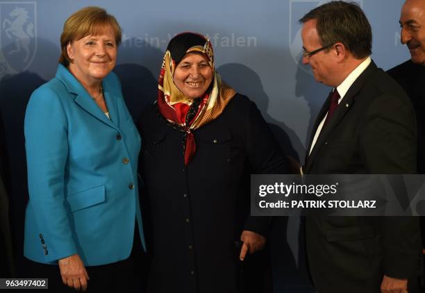 German Chancellor Angela Merkel smiles for a picture beside Mevlude Genc , mother, grandmother and aunt of the victims, North Rhine-Westphalia's...