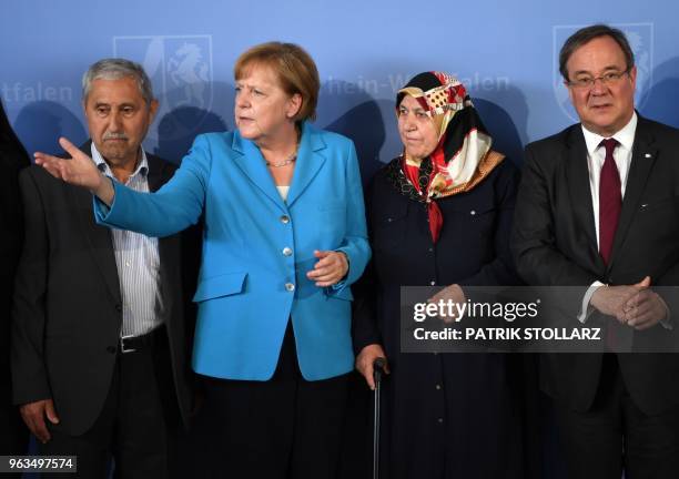 German Chancellor Angela Merkel reacts as she poses for a picture beside Mevlude Genc , mother, grandmother and aunt of the victims, her husband...