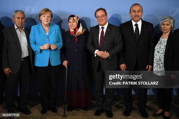 German Chancellor Angela Merkel poses for a picture beside Mevlude Genc , mother, grandmother and aunt of the victims, her husband Durmus Genc ,...