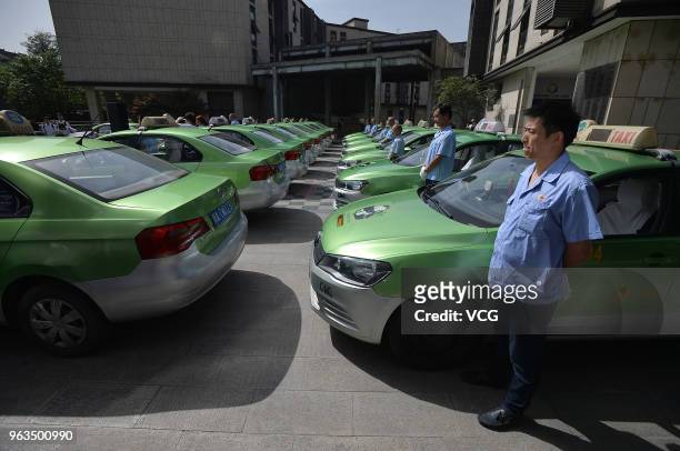 Taxis and drivers line up during a launch ceremony of a public welfare activity held by Chengdu Taxi at a college students pioneer park on May 28,...