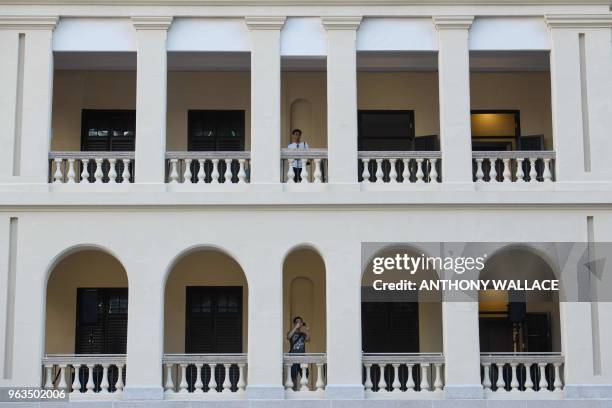 People look out from a balcony as they visit Victoria Prison, a former colonial prison and police station colloquially known as Tai Kwun, or "big...
