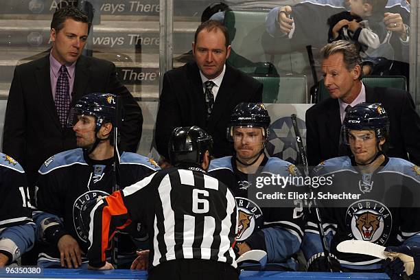 Head coach Peter DeBoer of the Florida Panthers and Assistant Coaches Jim Hulton and Mike Kitchen listen to NHL Referee Dan Marouelli after a video...