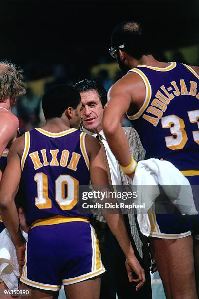 Head coach Pat Riley of the Los Angeles Lakers talks with Norm Nixon and Kareem Abdul-Jabbar during a game against the Boston Celtics played in 1982...