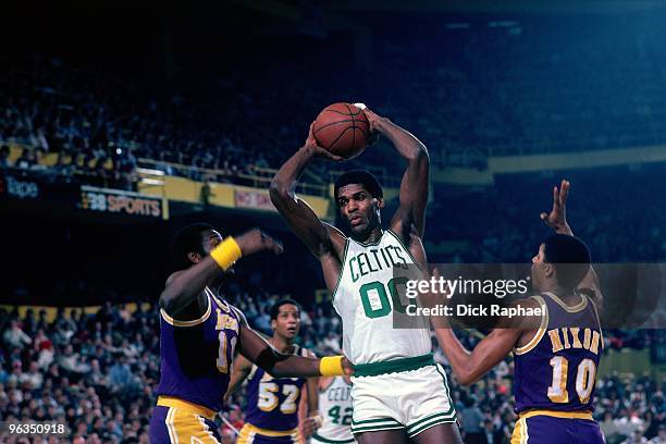 Robert Parish of the Boston Celtics rebounds against Bob McAdoo and Norm Nixon of the Los Angeles Lakers during a game played in 1982 at the Boston...