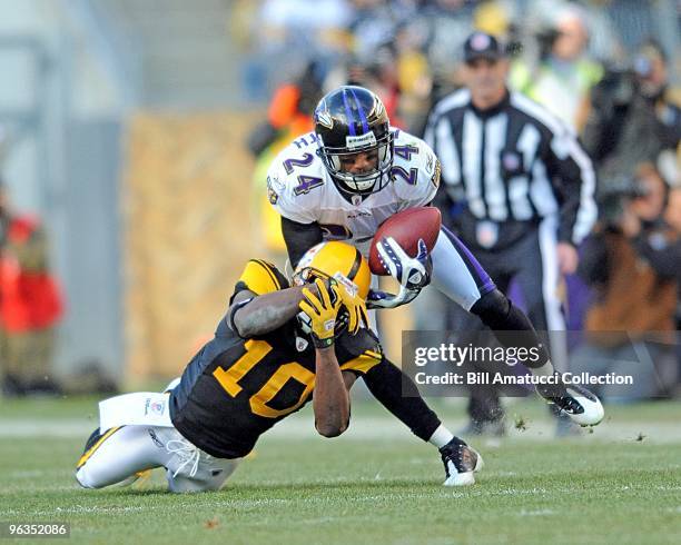 Cornerback Domonique Foxworth of the Baltimore Ravens intercepts a pass in front of wide receiver Santonio Holmes of the Pittsburgh Steelers during a...