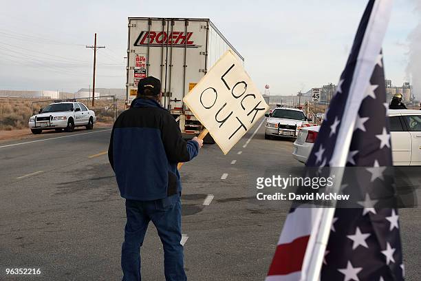Locked out worker holds a sign as a truck enters the front gate of the Rio Tinto Borax mine two days after mine owners locked out about 540 employees...