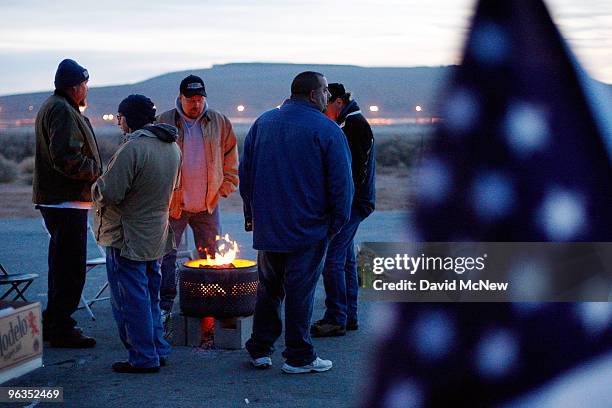 Locked out workers stay warm by a fire as they keep vigil near the front gate of the Rio Tinto Borax mine two days after mine owners locked out about...