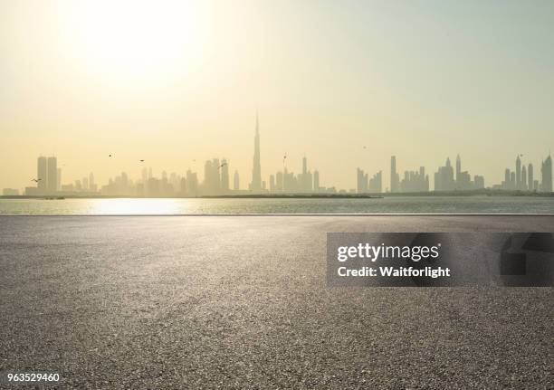 empty parking lot with dubai skyline background - dubai road stock pictures, royalty-free photos & images