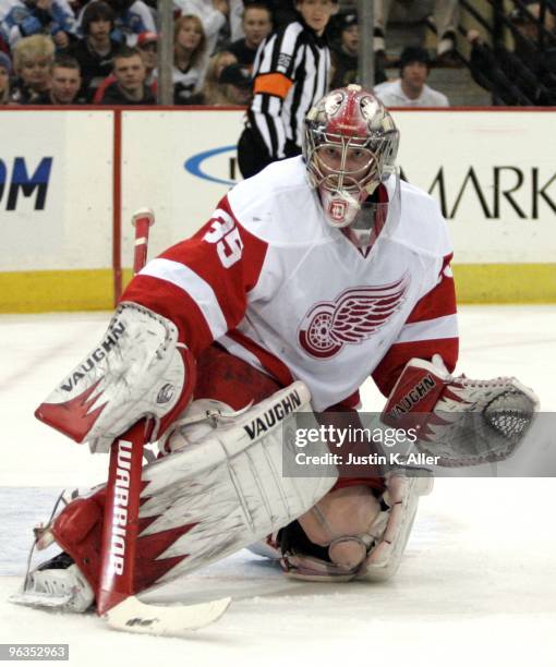 Jimmy Howard of the Detroit Red Wings eyes a puck in the corner against the Pittsburgh Penguins at Mellon Arena on January 31, 2010 in Pittsburgh,...