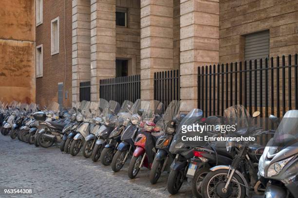 parked motorbikes on a side street in rome. - emreturanphoto stock-fotos und bilder