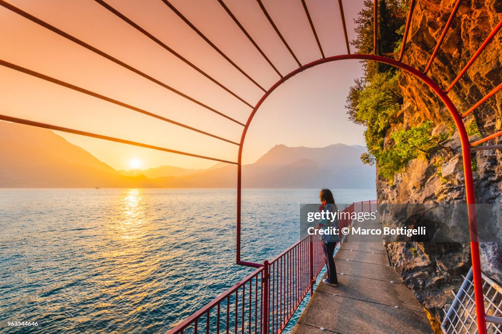 Woman tourist enjoying sunset in Varenna, lake Como, Italy