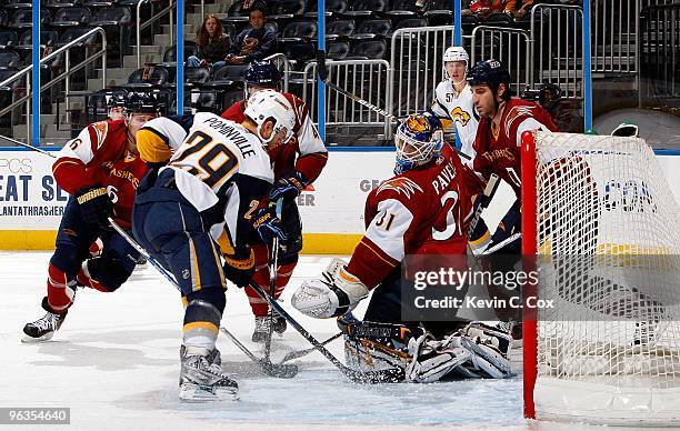 Goaltender Ondrej Pavelec and Chris Thorburn of the Atlanta Thrashers against Jason Pominville of the Buffalo Sabres at Philips Arena on January 14,...