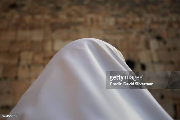 An ultra-Orthodox Jew is wrapped in his Tallit, or prayer shawl, as he recites his daily prayers at the Western Wall on February 2, 2010 in...