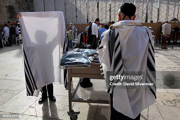 An ultra-Orthodox Jew prepares to wear his Tallit, or prayer shawl, to join others at morning prayers at the Western Wall on February 2, 2010 in...