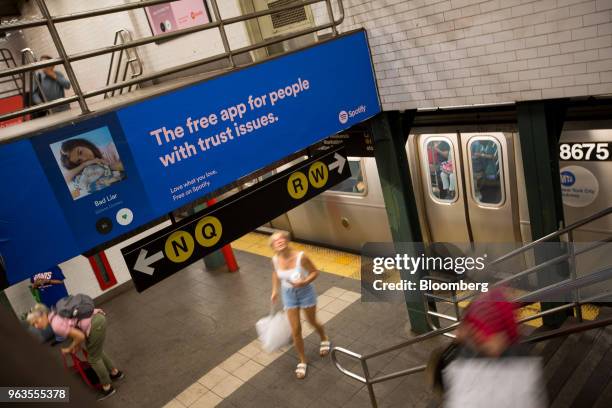 Commuters pass Spotify Technology SA advertisements displayed inside the Union Square subway station in New York, U.S., on Friday, May 25, 2018. In a...