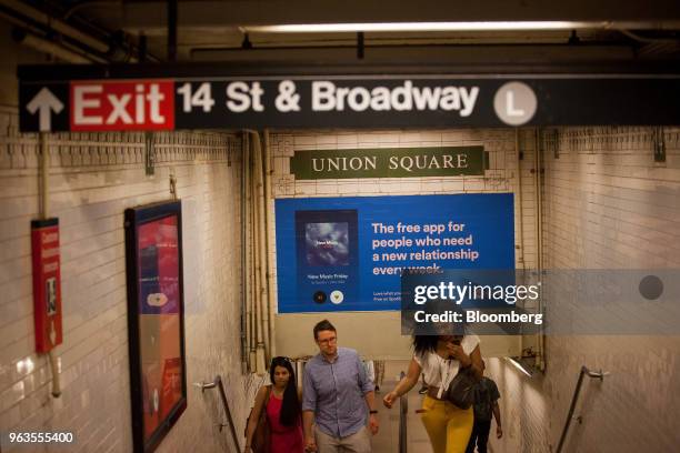 Commuters pass Spotify Technology SA advertisements displayed inside the Union Square subway station in New York, U.S., on Friday, May 25, 2018. In a...