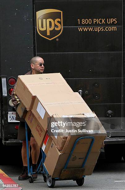 United Parcel Service driver Grant Jung pushes a handtruck loaded with boxes as he makes deliveries February 2, 2010 in San Francisco, California....