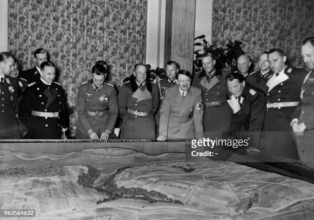 Commander-in-chief of the German Army, General Walther von Brauchitsch stands next to Führer Adolf Hitler , looking at a model offered by the German...