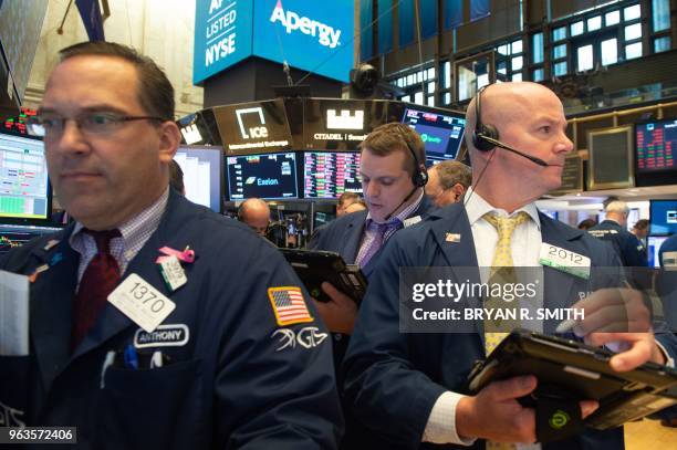 Traders work on the floor of the Dow Industrial Average at the New York Stock Exchange on May 29, 2018 in New York. - US stocks retreated early...