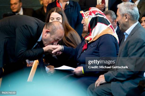 Mevlut Cavusoglu, Foreign Minister of Turkey, kisses the hand of Mevlude Genc during the commemoration of the arson attack on the house of the...