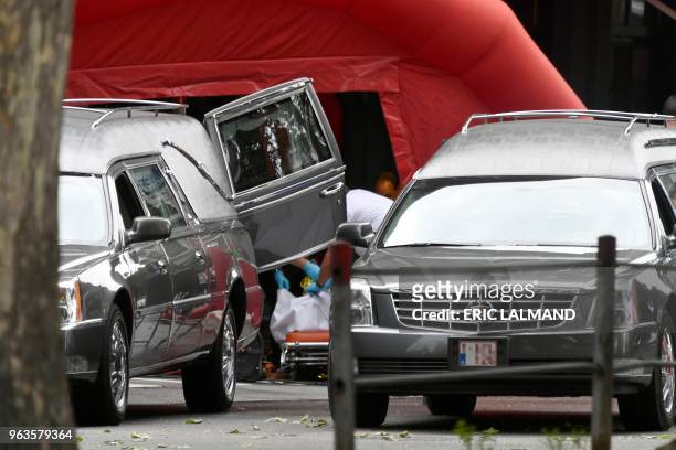 Hearses are pictured inside the security perimeter set by the police at the scene of a shooting in Liege, on May 29 after a gunman killed two female...