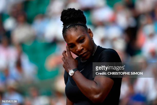 Serena Williams of the US gestures as she walks on court after a point against Czech Republic's Kristyna Pliskova during their women's singles first...