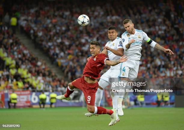 Roberto Firmino of Liverpool heads the ball with Sergio Ramos and Casemiro of Real Madrid during the UEFA Champions League Final between Real Madrid...