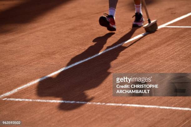 Groundstaff sweep the playing surface after the women's singles first round match between Slovakia's Dominika Cibulkova and Germany's Julia Goerges,...