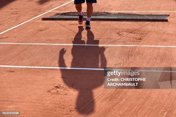 Groundstaff sweep the playing surface after the women's singles first round match between Slovakia's Dominika Cibulkova and Germany's Julia Goerges,...