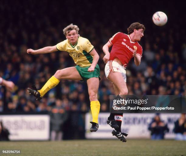 Robert Fleck of Norwich City and Steve Bruce of Manchester United compete in the air during a Barclays League Division One match at Carrow Road on...