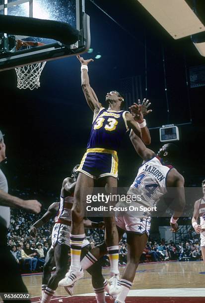 S: Kareem Abdul-Jabbar of the Los Angeles Lakers goes up for a rebound over Rick Mahorn of the Capital Bullets during a circa 1980's NBA basketball...