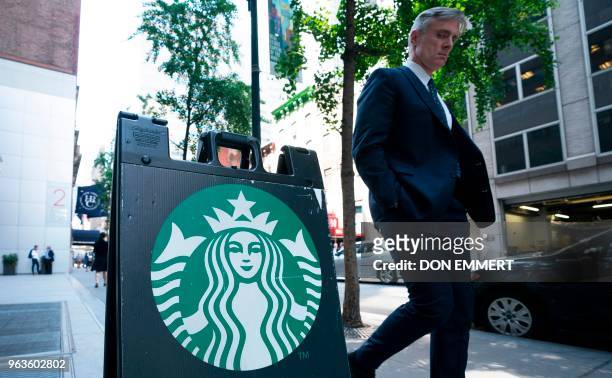Man walks past a sign on the sidewalk for Starbucks May 29, 2018 in New York. - Starbucks closed more than 8,000 stores across the US Tuesday to...