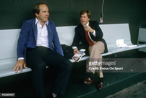 Commentator/sportscaster Bob Costas talks with retired Cincinnati Reds catcher Johnny Bench in the dougout before a Major League Baseball game circa...
